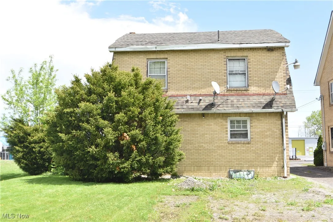 Back of house featuring brick siding, a yard, and crawl space