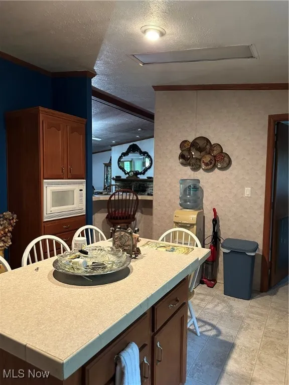 Island featuring a textured ceiling and crown molding