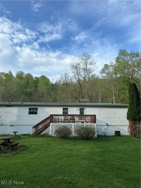 Rear view of property with a yard and a deck