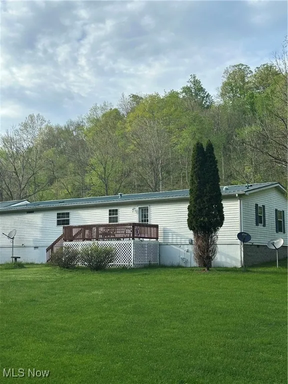 Rear view of property with a yard and a deck