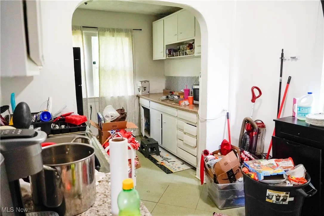 Kitchen with arched walkways and light countertops