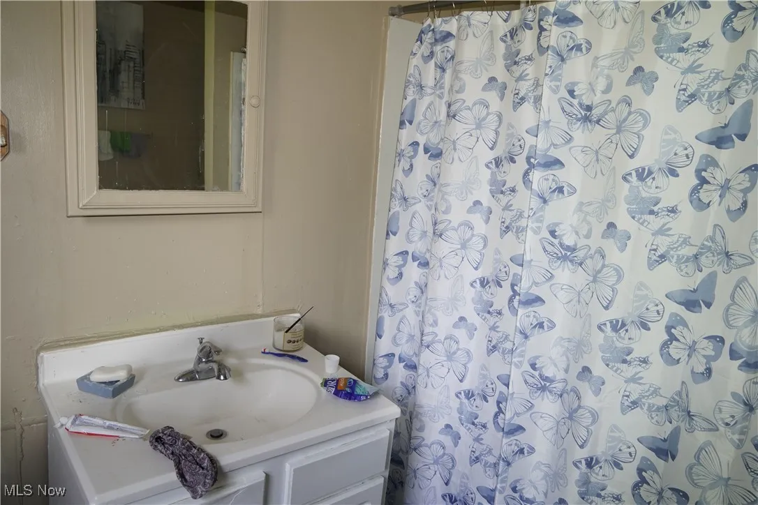 Full bath with vanity and a shower with shower curtain