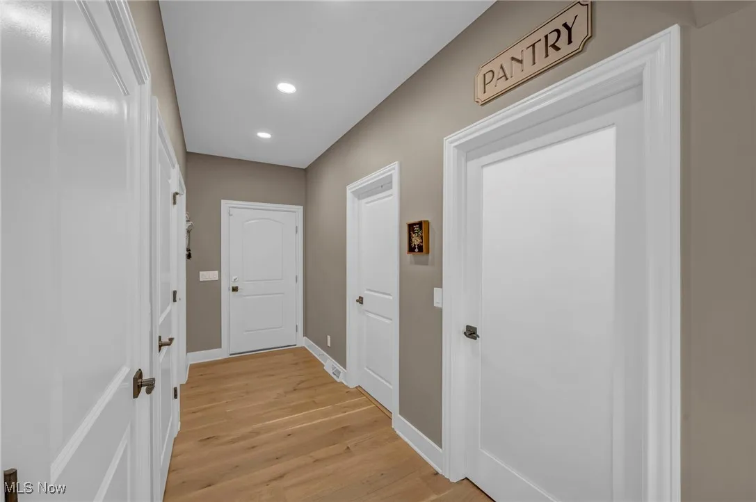 Doorway featuring recessed lighting, light wood-style floors, and baseboards