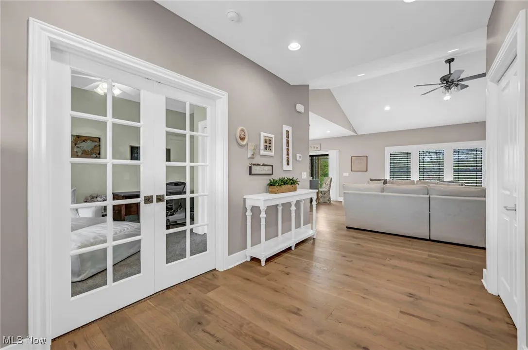 Living room featuring ceiling fan, lofted ceiling, french doors, wood finished floors, and recessed lighting