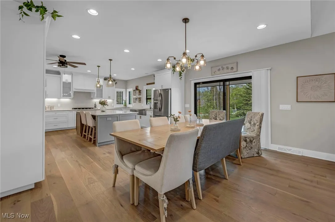 Dining area with light wood-style flooring, recessed lighting, plenty of natural light, a chandelier, and a ceiling fan