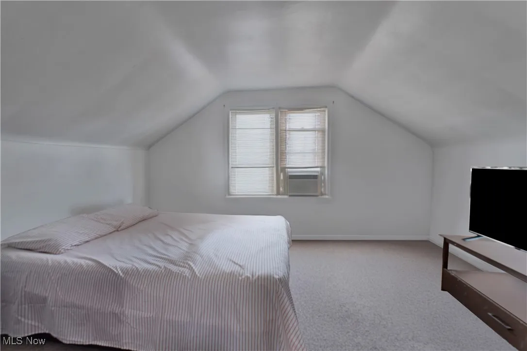 Bedroom with carpet, lofted ceiling, and baseboards