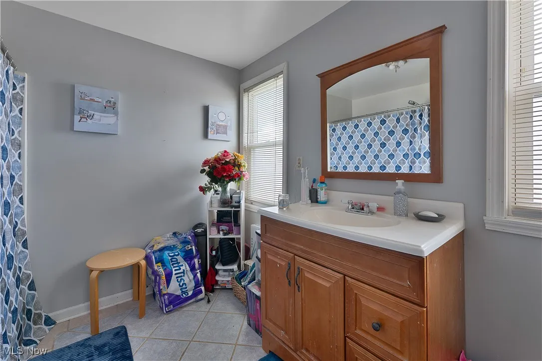 Bathroom featuring healthy amount of natural light, tile patterned floors, and vanity