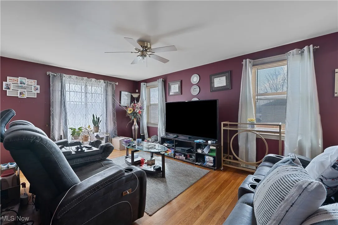 Living room with healthy amount of natural light, ceiling fan, and wood finished floors