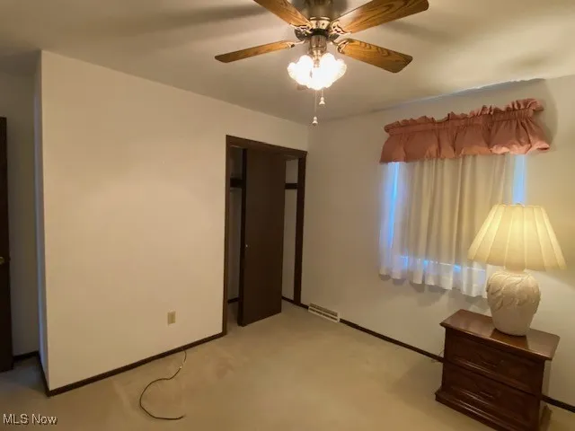 Bedroom featuring light colored carpet and a ceiling fan