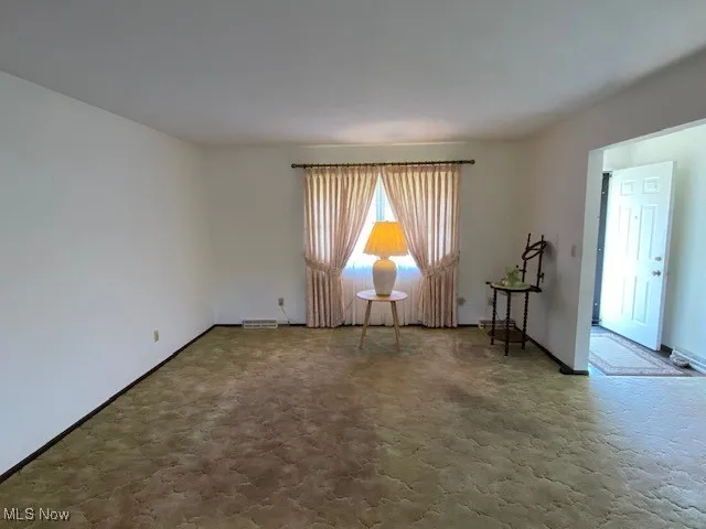 Carpeted empty room with baseboards