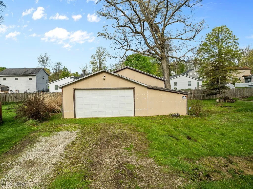 Detached garage featuring driveway and a residential view