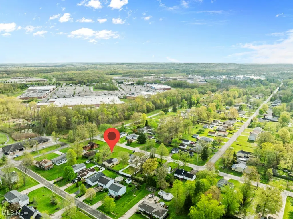 Aerial view of property and surrounding area featuring nearby suburban area