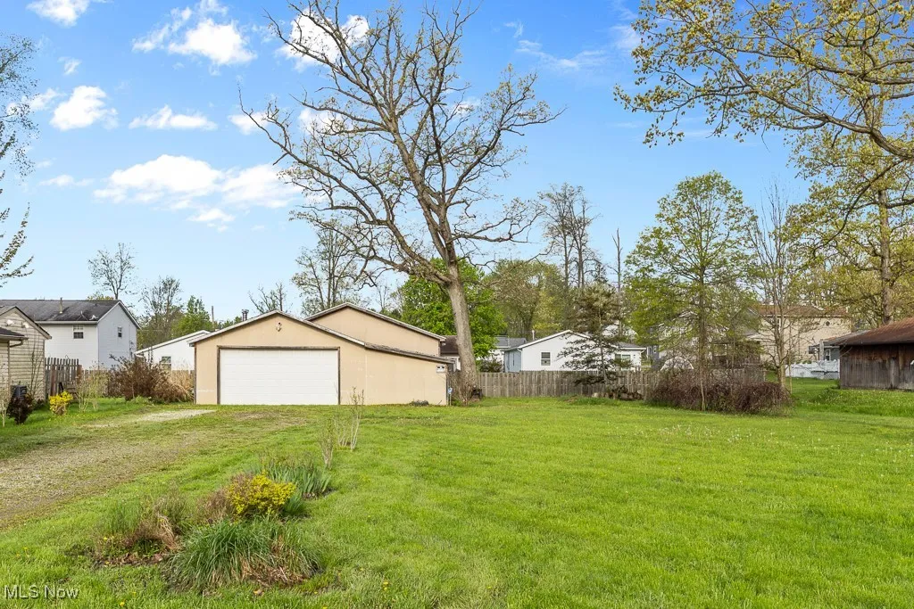 View of yard featuring a garage, an outdoor structure, and driveway
