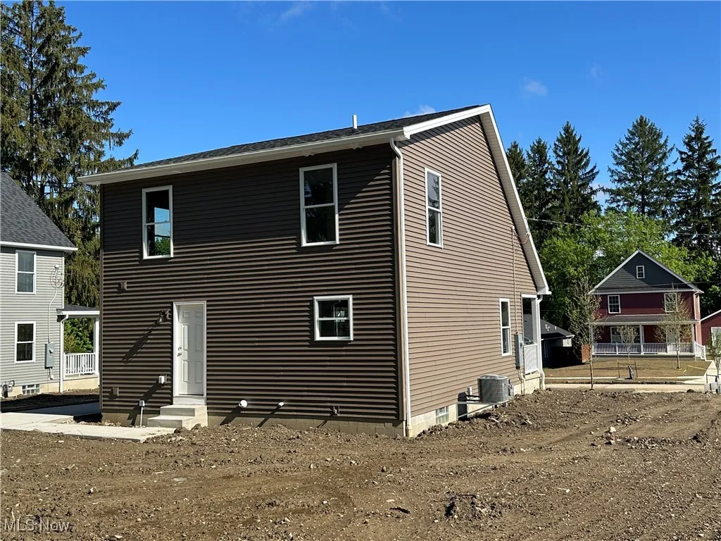 Back of house featuring entry steps and central AC