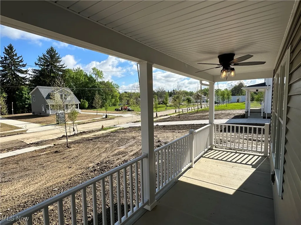 Covered front porch with a ceiling fan