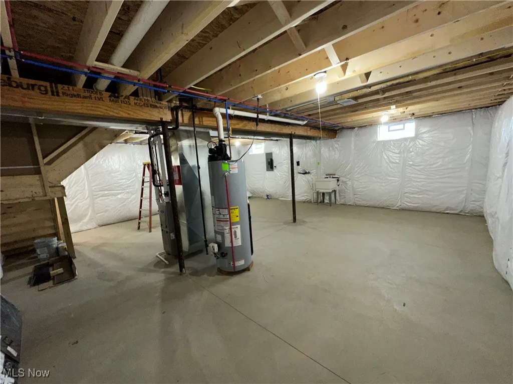 Below grade area featuring gas water heater and a sink