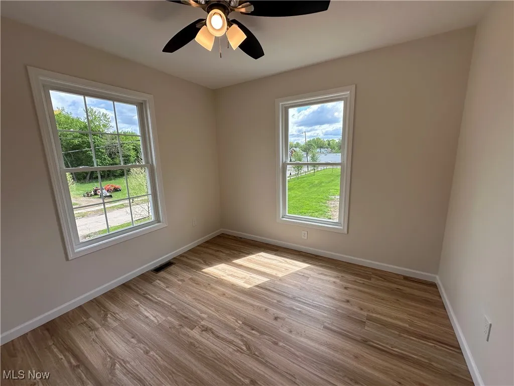 Unfurnished bedroom featuring baseboards, LVT floors, and a ceiling fan