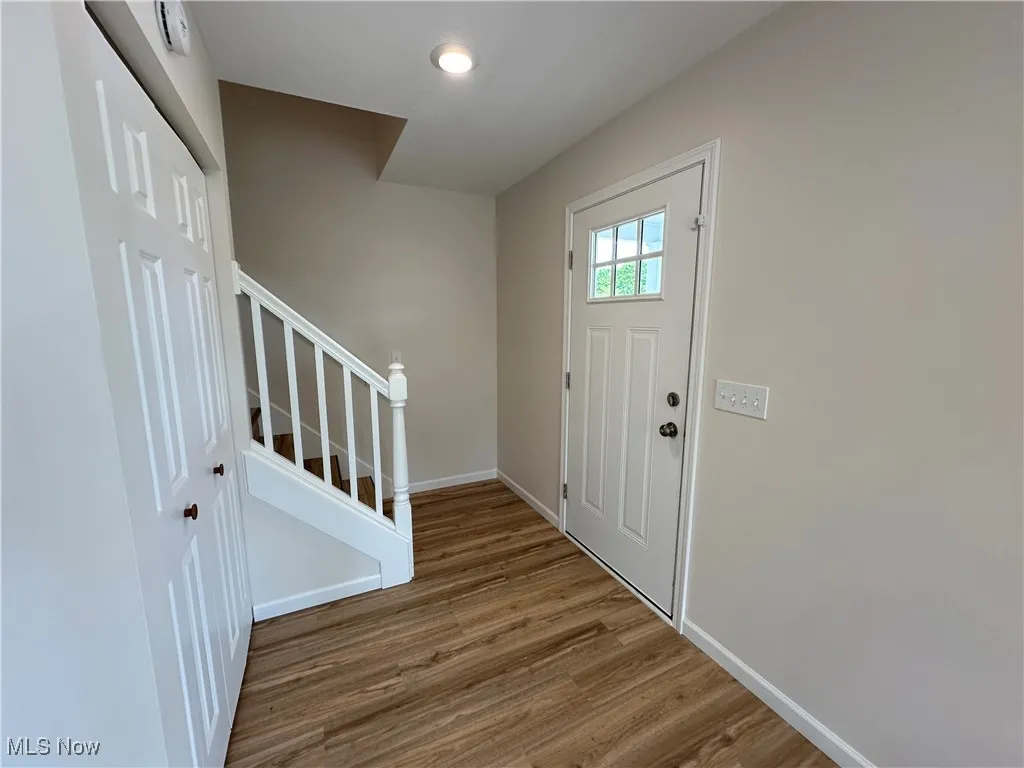 Foyer with stairs, LVT floors, baseboards, and recessed lighting