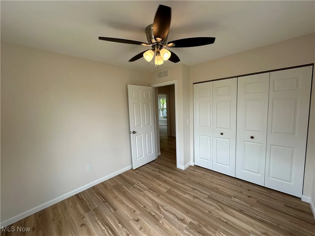Unfurnished bedroom with baseboards, light LVT floors, a closet, and ceiling fan