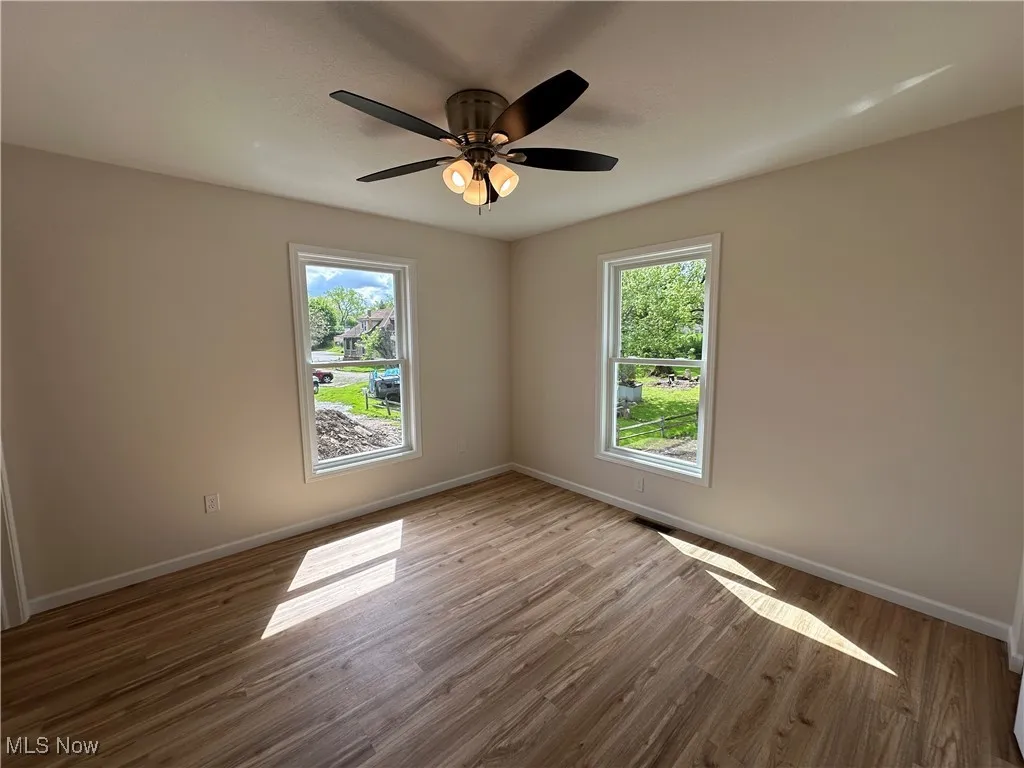 Unfurnished bedroom with plenty of natural light, LVT floors, and baseboards