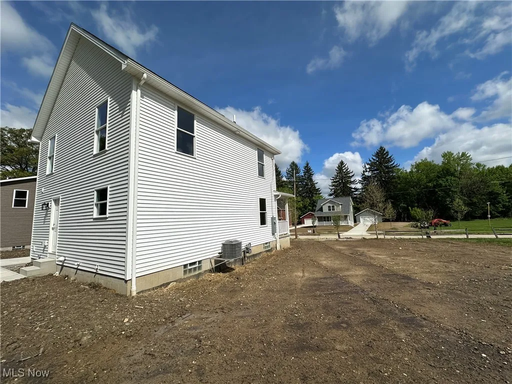 View of side of home featuring entry steps and central air condition unit