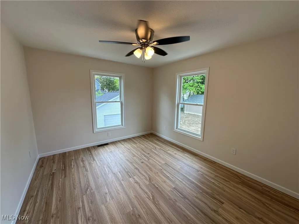 Bedroom featuring plenty of natural light, LVT floors, baseboards, and a ceiling fan