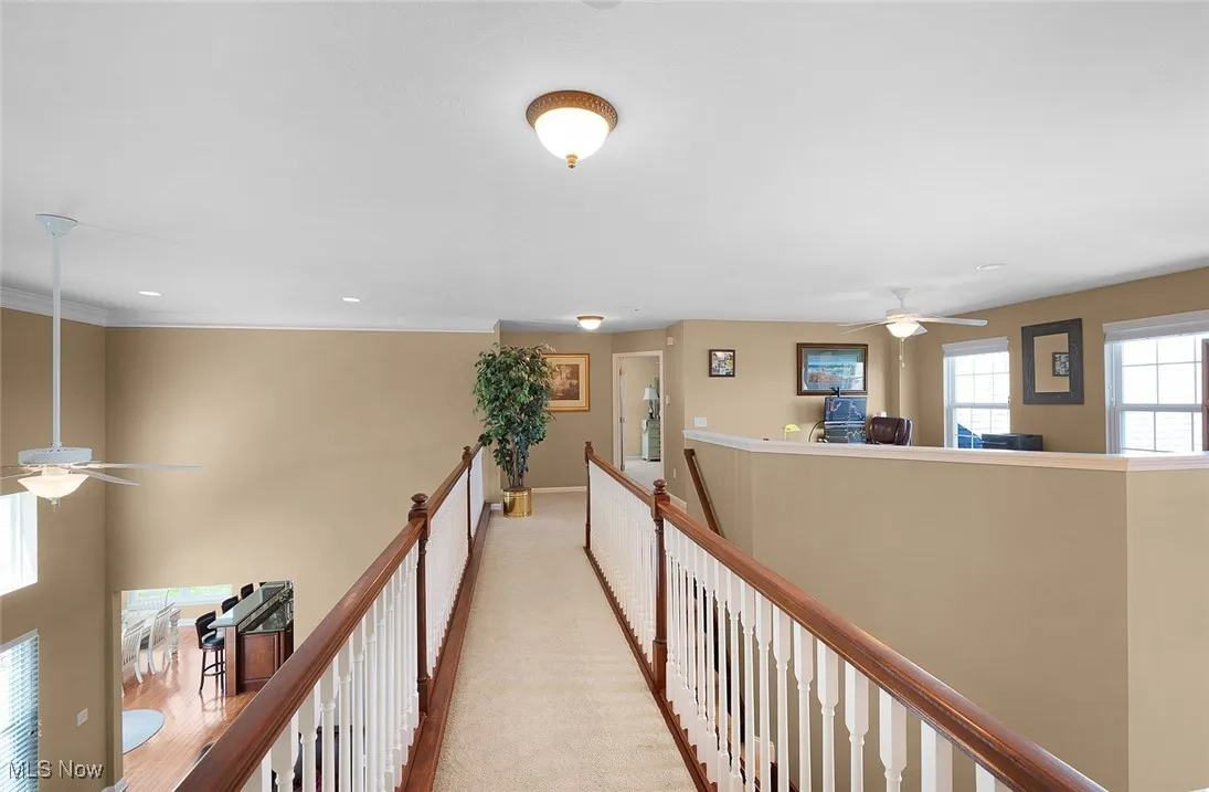 Hall with an upstairs landing, baseboards, and recessed lighting