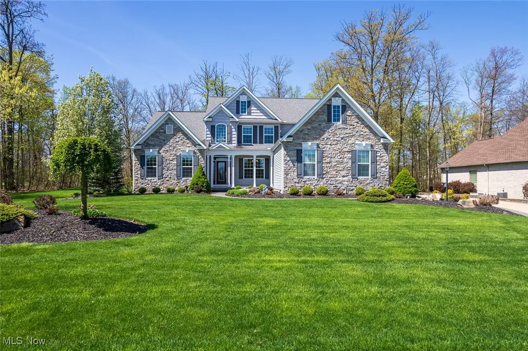 Craftsman-style home with stone siding and a front yard