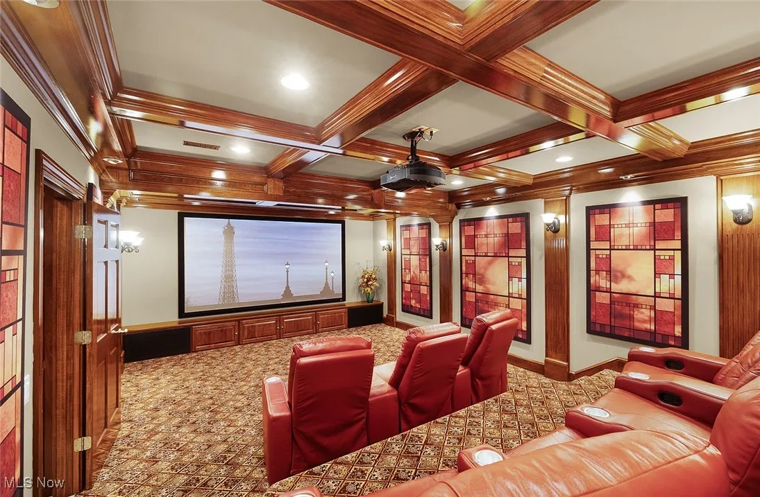 Cinema featuring carpet, beam ceiling, coffered ceiling, baseboards, and crown molding