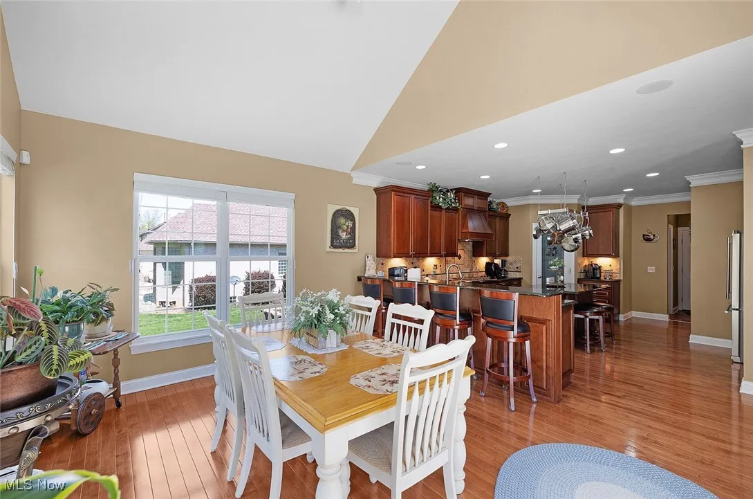 Dining area featuring baseboards, light wood finished floors, ornamental molding, a chandelier, and recessed lighting
