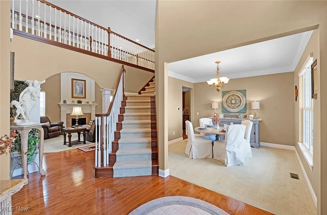 Entryway with hardwood / wood-style floors, ornamental molding, baseboards, a fireplace, and stairway