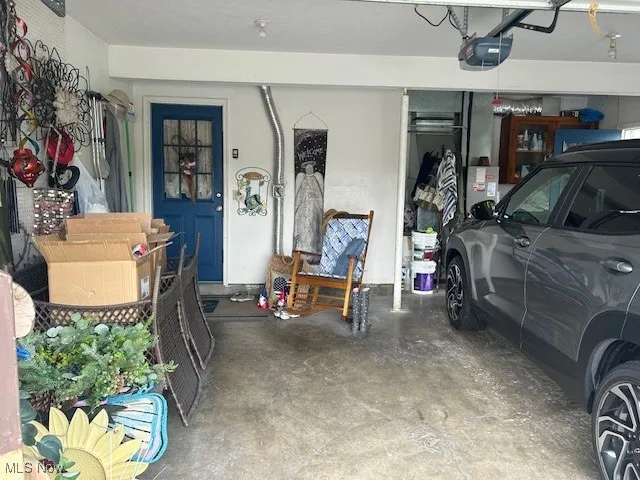 Garage featuring a garage door opener and LOTS of storage.