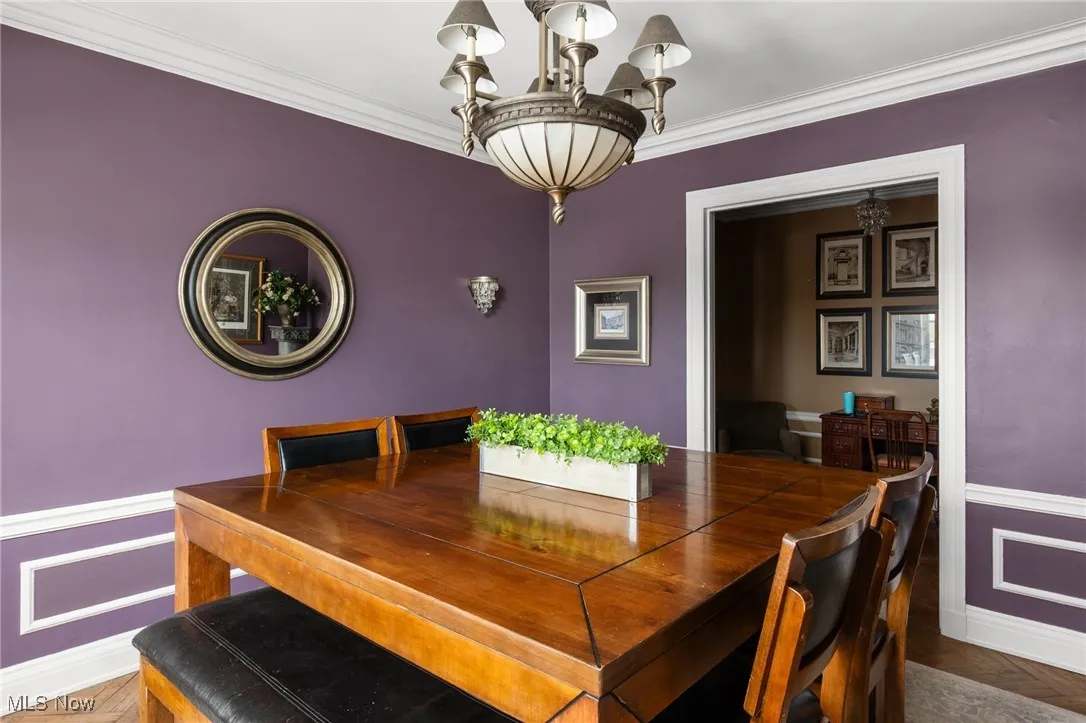 Dining space featuring crown molding, a chandelier, and baseboards