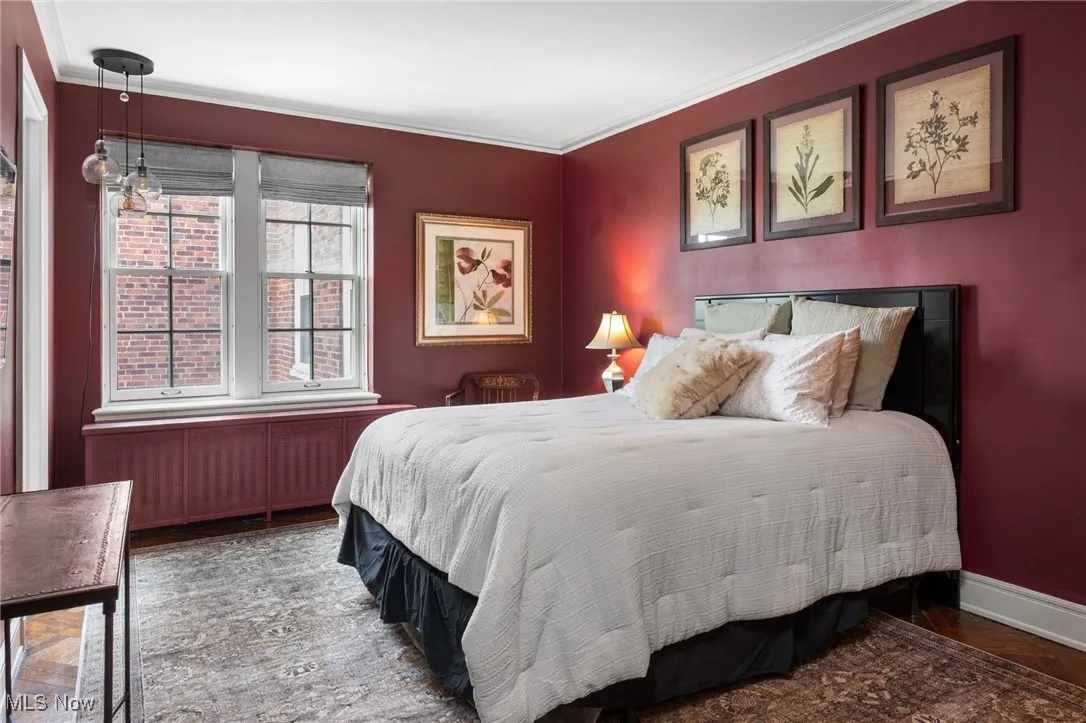 Bedroom with baseboards, crown molding, and wood finished floors