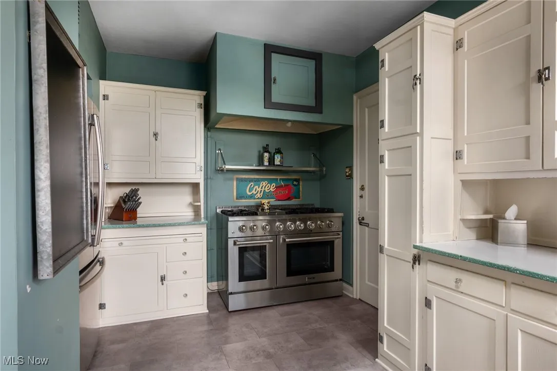Kitchen featuring stainless steel appliances and white cabinetry
