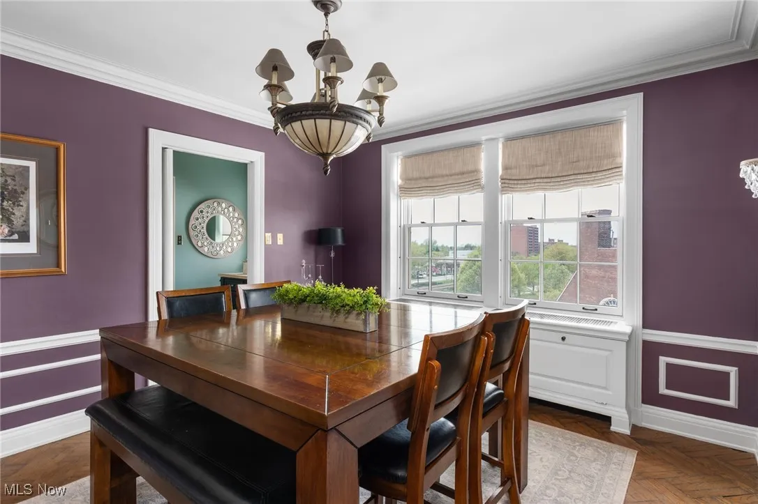 Dining room with a chandelier, crown molding, and baseboards