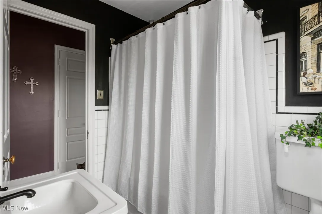 Bathroom featuring a shower with curtain and a sink