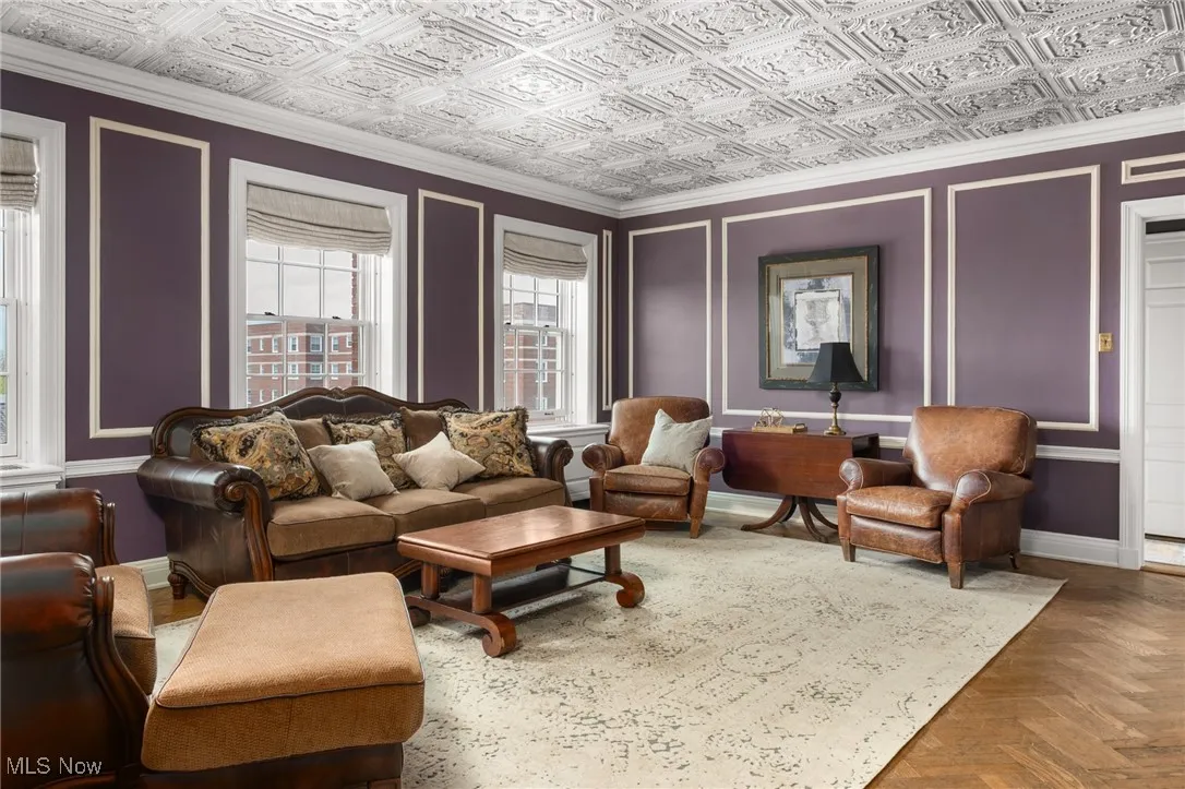 Living area with baseboards and an ornate ceiling