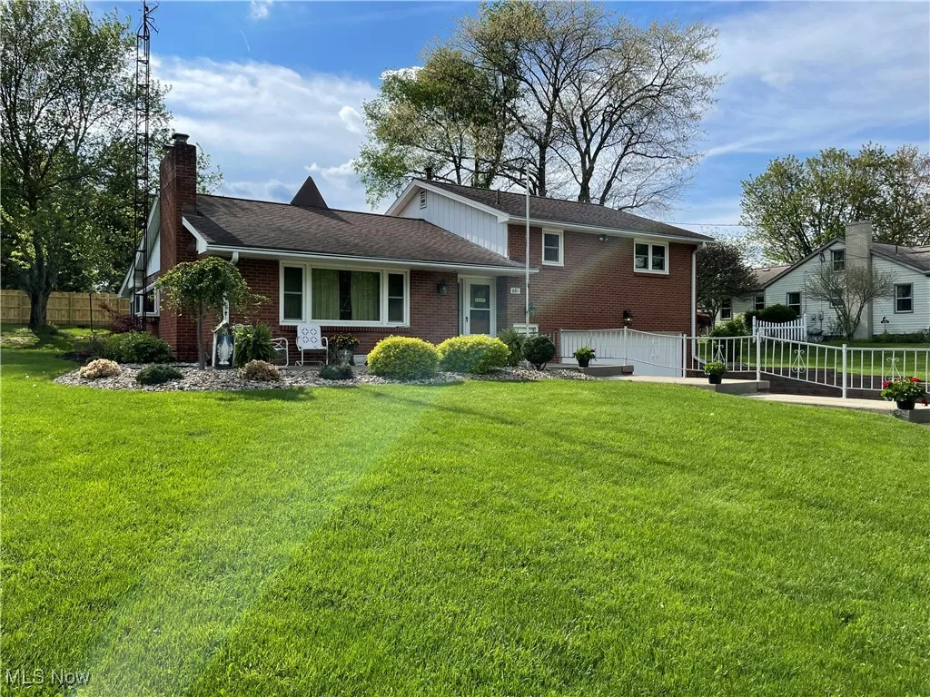 Front of house with brick siding, an attached garage, and a chimney