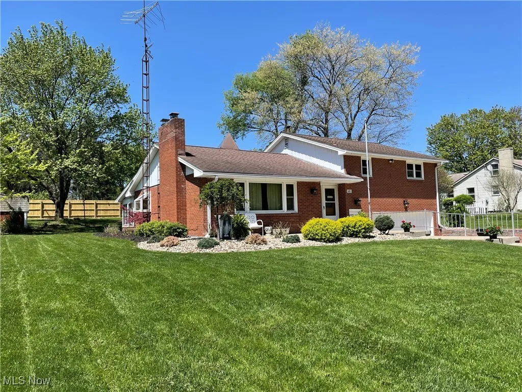 Rear view of property with a chimney and brick siding