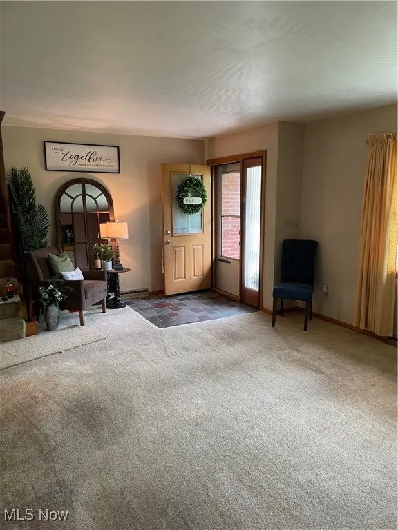 Foyer entrance featuring carpet floors and baseboards