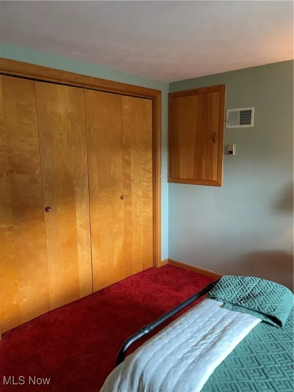 Carpeted bedroom with a closet