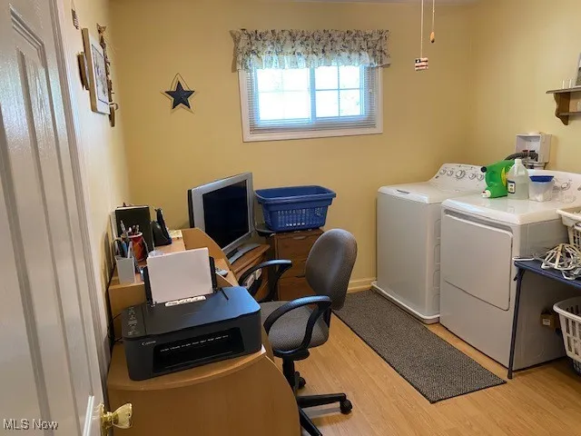 Laundry area featuring separate washer and dryer and wood finished floors