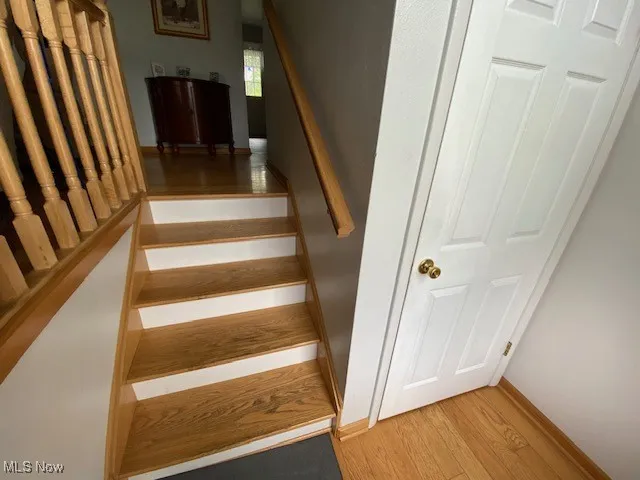 Staircase featuring wood finished floors and baseboards