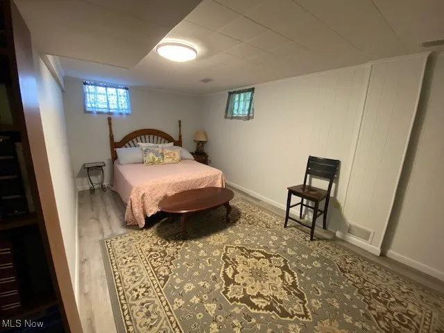 Bedroom featuring wood finished floors and baseboards