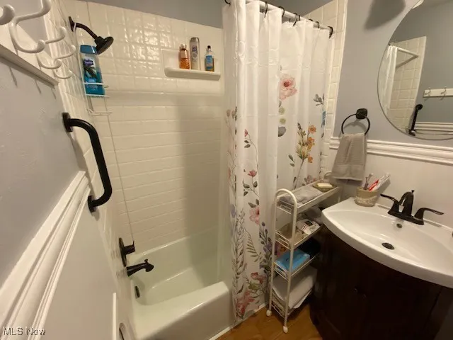 Bathroom featuring shower / tub combo with curtain, vanity, and wood finished floors