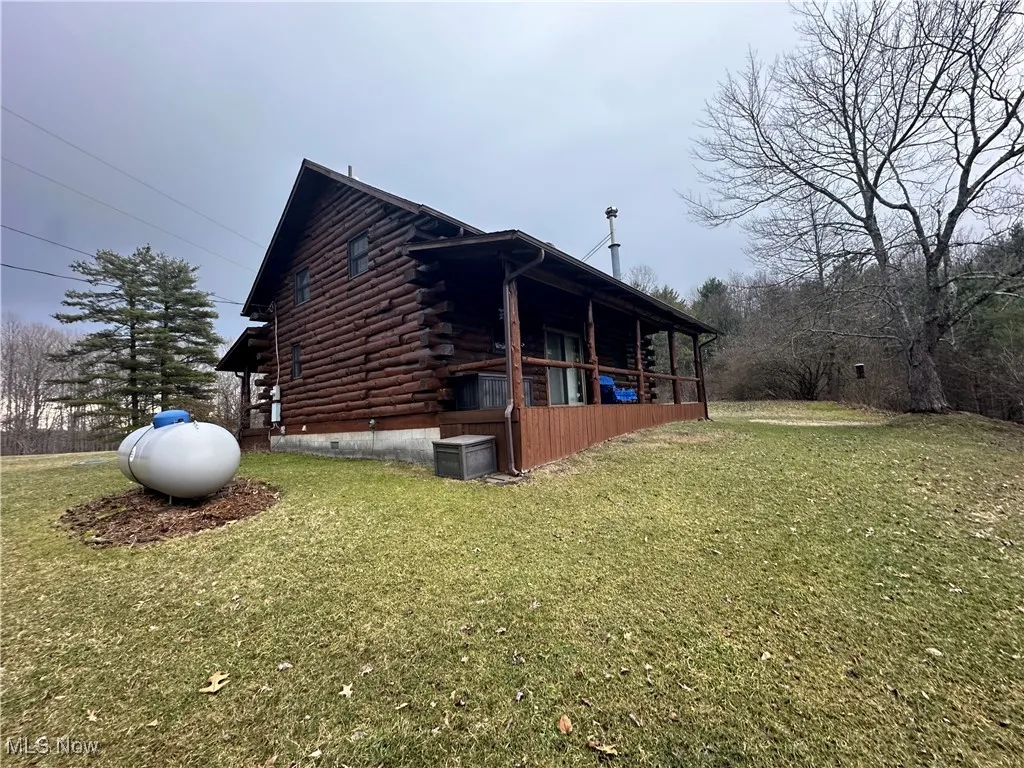 View of home's exterior featuring log exterior, a lawn, crawl space, and central air condition unit
