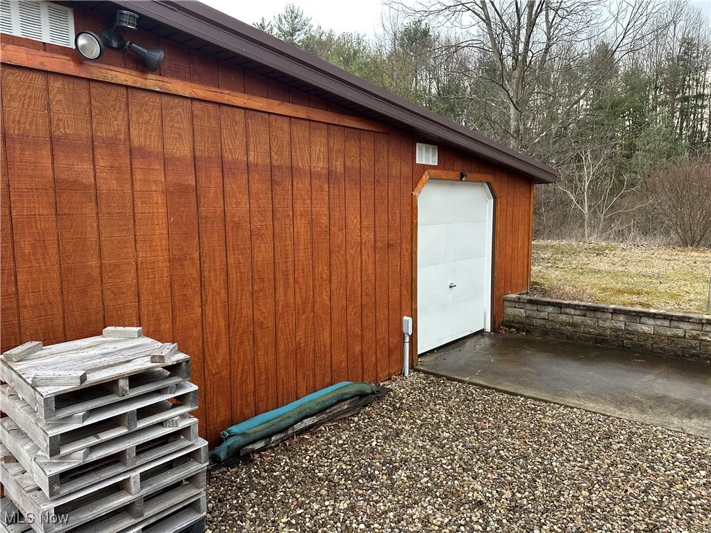 View of outdoor shed with garage door.