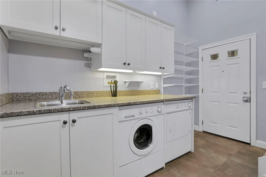 Washroom featuring washing machine and dryer and cabinet space