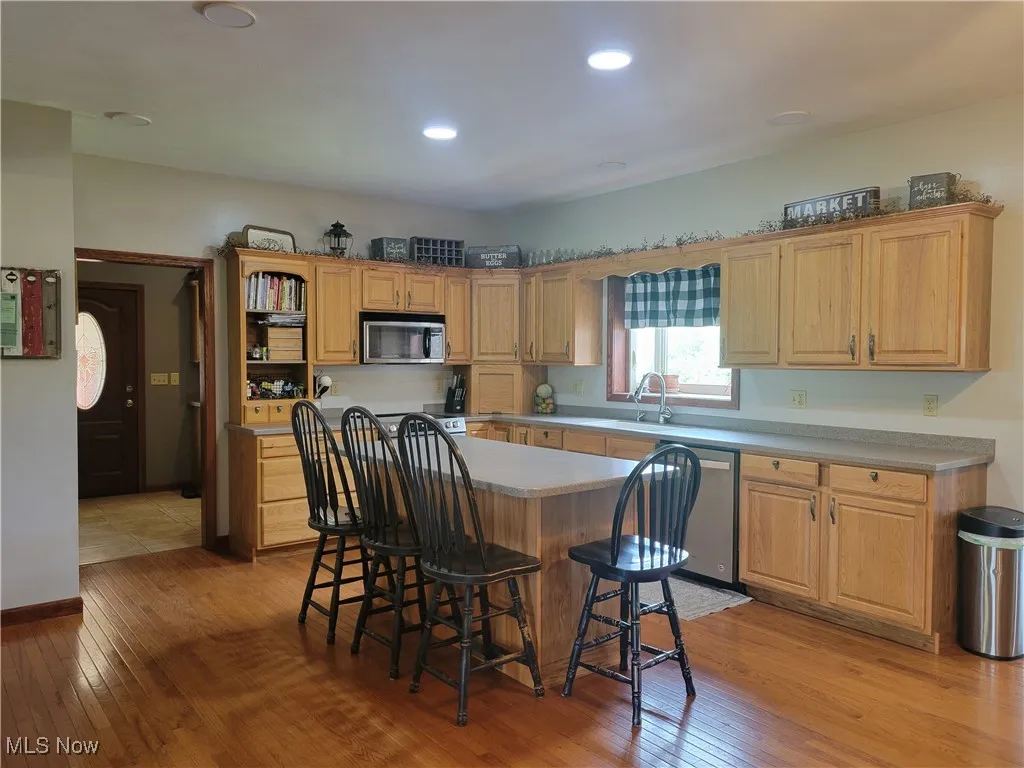 Kitchen with stainless appliances, large island, hardwood flooring